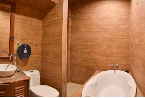 a bathroom with a tub and a toilet and a sink at Colonial House Mekong River View in Luang Prabang
