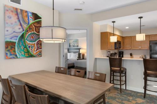 a kitchen and dining room with a dining table and a room with a bed at Club Wyndham La Cascada in San Antonio