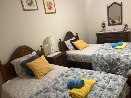 a bedroom with two beds and a mirror at Casa da Ramada - Water SPA Tank with running natural spring water - by Bedzy in Braga