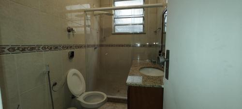 a bathroom with a toilet and a sink and a shower at Bem te vi in Niterói