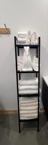 a towel rack with white towels and white shoes at NOvO Chalet in Saint-David-de-Falardeau