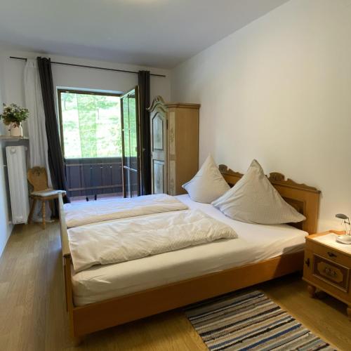 a bedroom with a large bed and a window at Weberhof in Samerberg