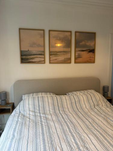a bedroom with three pictures on the wall and a bed at Flat in Lundin Links in Lundin Links