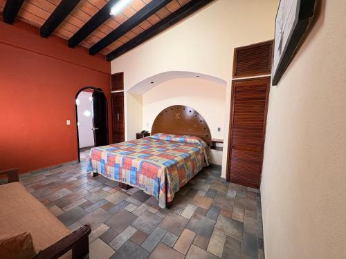 una camera da letto con un letto in una stanza con pareti rosse di Hotel Mocali a Puerto Vallarta