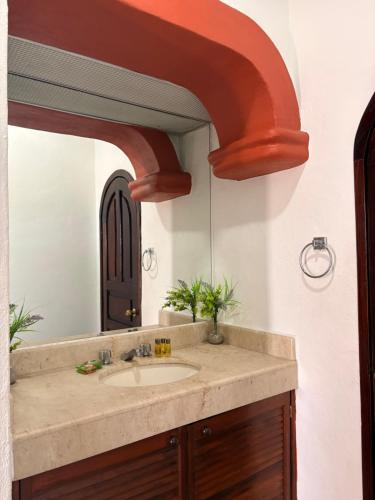un bagno con lavandino e specchio di Hotel Mocali a Puerto Vallarta