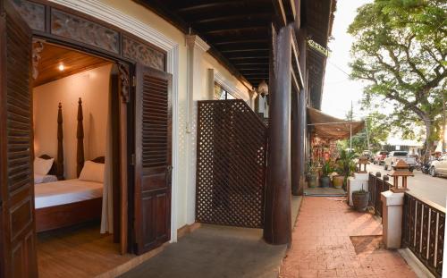 an open door to a room with a bed on a porch at Colonial House Mekong River View in Luang Prabang