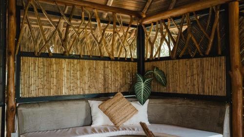 a room with a couch in a straw hut at WISIRARE ECOLODGE - Luxury experience in Yopal