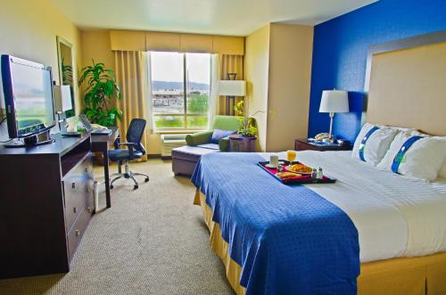 a hotel room with a large bed and a television at Holiday Inn & Suites Phoenix Airport by IHG in Phoenix