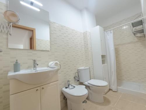 a bathroom with a sink and a toilet and a mirror at HOME CENTRO B max 5 personas HOME CENTRO A max 6 personas in Marchena