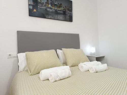 a bed with white towels on top of it at HOME CENTRO B max 5 personas HOME CENTRO A max 6 personas in Marchena