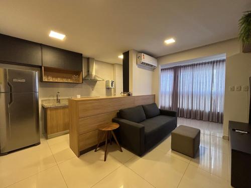 a kitchen with a couch and a chair in a room at Apart St Bueno Ar, Cozinha, Garagem Próx Órion in Goiânia