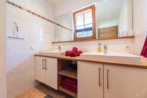 a bathroom with two sinks and a mirror at Samerhäusl in Bruck an der Großglocknerstraße
