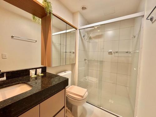 a bathroom with a shower and a toilet and a sink at Apart St Bueno SuperKing Ar, Cozinha, Vaga in Goiânia