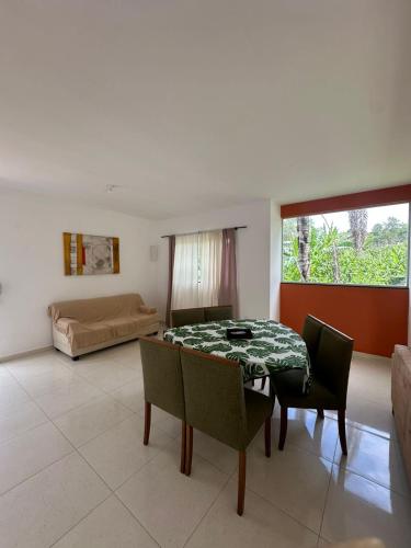 a living room with a table and chairs and a bed at Casinha da Val in Atibaia