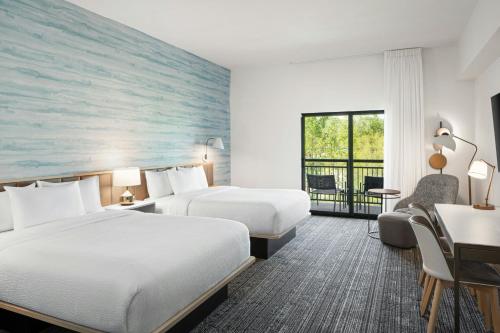 a hotel room with two beds and a desk at TownePlace Suites Pigeon Forge in Pigeon Forge