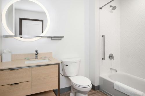 a bathroom with a toilet and a sink and a mirror at TownePlace Suites Pigeon Forge in Pigeon Forge