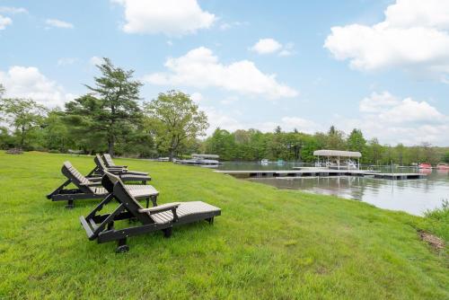 a group of lounge chairs on a grassy hill next to a river at Starry Night by Railey Vacations in Swanton