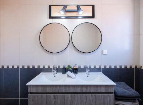 two mirrors above a white sink in a bathroom at Vila da Pesca House in Rabo de Peixe