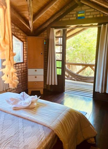 a bedroom with a bed in a room with a window at Hospedaria LARENA in Florianópolis