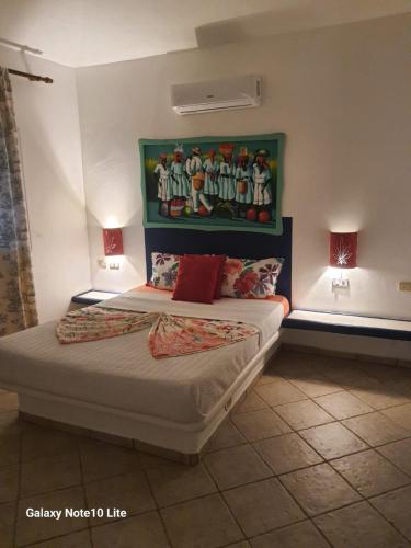 a bedroom with a bed with a painting on the wall at Casa Flamingo in Las Terrenas