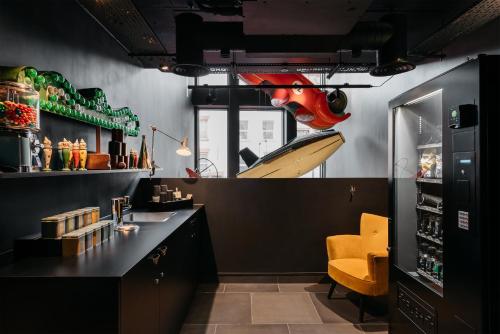 eine Bar mit einem gelben Stuhl in einem Raum in der Unterkunft Ruby Lucy Hotel London by IHG in London