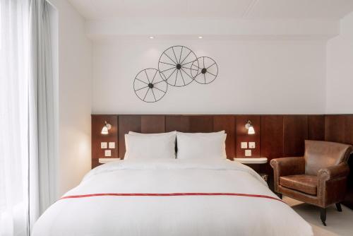 ein Schlafzimmer mit einem großen Bett und einem Stuhl in der Unterkunft Ruby Lucy Hotel London by IHG in London