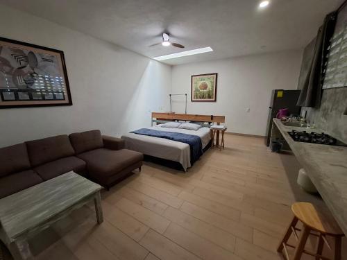 a living room with a bed and a couch at Loft con Jardín amplio 3 in Puerto Vallarta