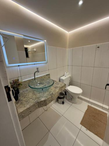 a bathroom with a sink and a toilet at Downtown Rooftop 375 in Imbetiba