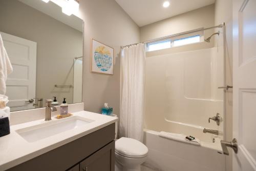 a bathroom with a sink and a toilet and a shower at Sunflower Beach Cottage in Ocean Shores
