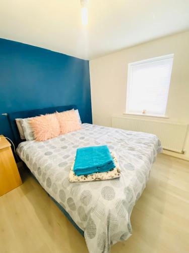 a bedroom with a bed with a blue wall at Stay at LL in Doncaster