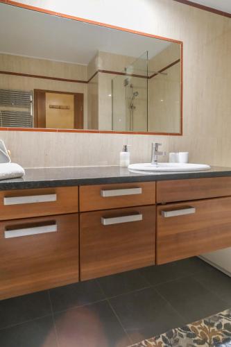 a bathroom with a sink and a large mirror at Casa Foz da Ria in Lagos