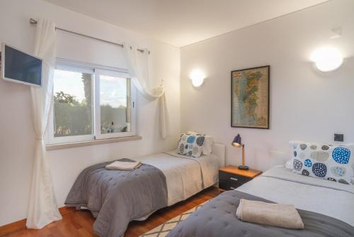 a bedroom with two beds and a window at Casa Foz da Ria in Lagos