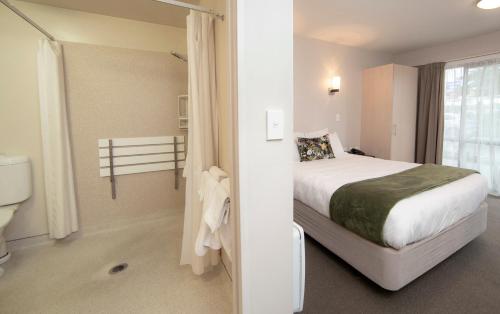 a hotel room with a bed and a toilet at Cranford Oak Motel in Christchurch