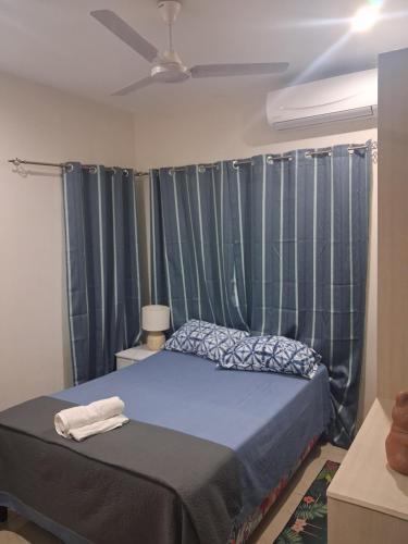 sypialnia z łóżkiem z niebieskimi zasłonami w obiekcie Alis786 Apartment w mieście Lautoka