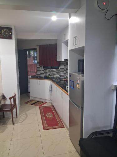kuchnia z białymi szafkami i lodówką w obiekcie Alis786 Apartment w mieście Lautoka