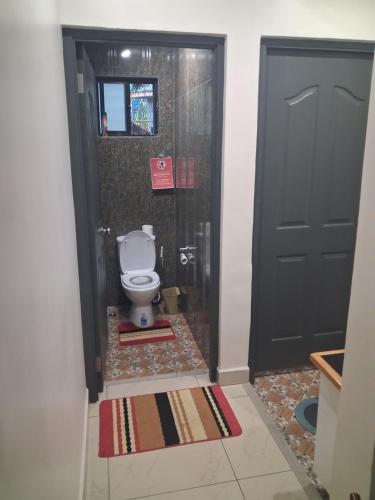 łazienka z toaletą i czarnymi drzwiami w obiekcie Alis786 Apartment w mieście Lautoka