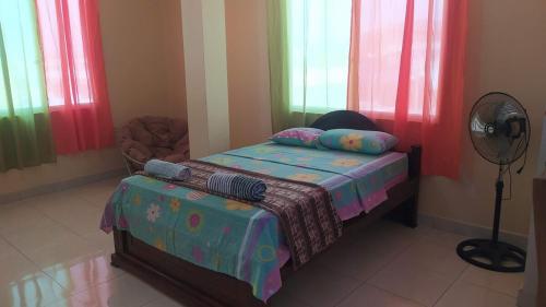 a bedroom with a bed and a fan and windows at Suite Crucita in Crucita