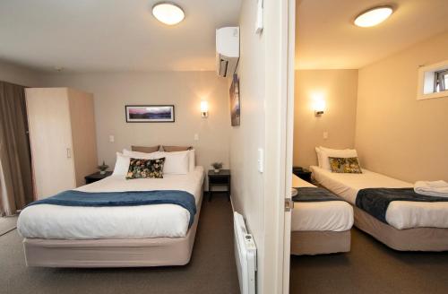 a hotel room with two beds and a hallway at Cranford Oak Motel in Christchurch