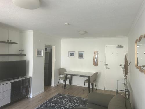 a living room with a table and a couch at Stylish 1-Bedroom Apartment in the Heart of Cremorne in Sydney