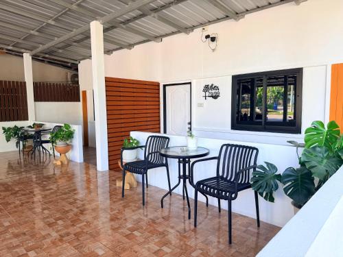a patio with a table and chairs and plants at Krabi Bloom House in Ban Khlong Khamao (2)