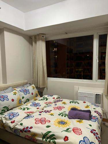 a bedroom with a bed with flowers on it at Faerydae Suites - Free Pool Access in Manila