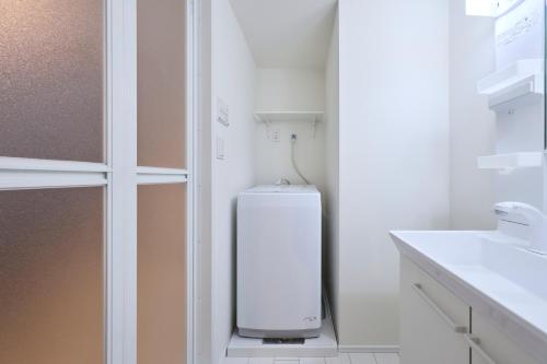 a bathroom with a small refrigerator in the corner at とりっぱーずホテル方南町 in Tokyo