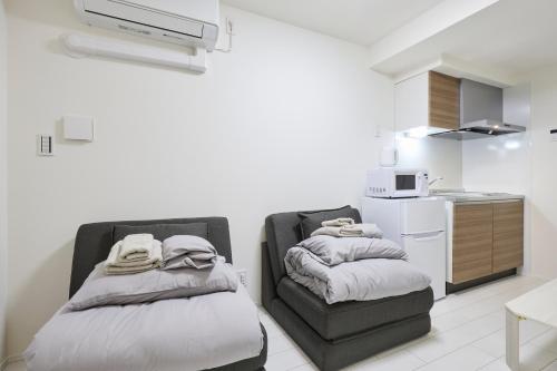 a room with two beds and a kitchen at とりっぱーずホテル方南町 in Tokyo