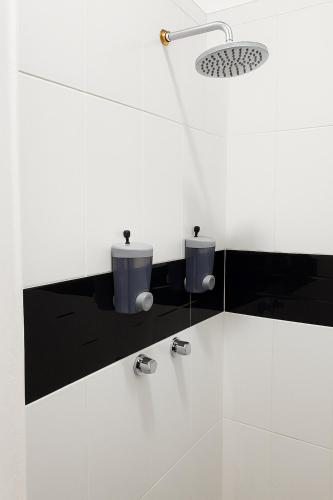 a white bathroom with two sinks and a shower at Hotel Fundidora - Regiotitlan in Monterrey