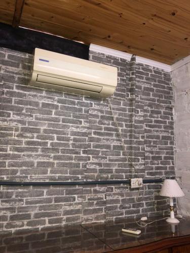 a light on a brick wall with a lamp at ApartCarina in General Acha