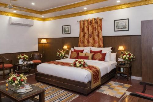 a hotel room with a large bed with flowers on it at Hotel Harmony in Khajurāho