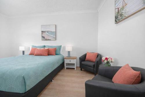 a bedroom with a bed and a couch and a chair at Waterfront Studio Room Near City Stadium & Ferry in Townsville in Townsville
