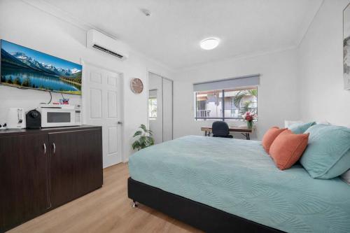 a bedroom with a bed and a kitchen with a microwave at Waterfront Studio Room Near City Stadium & Ferry in Townsville in Townsville