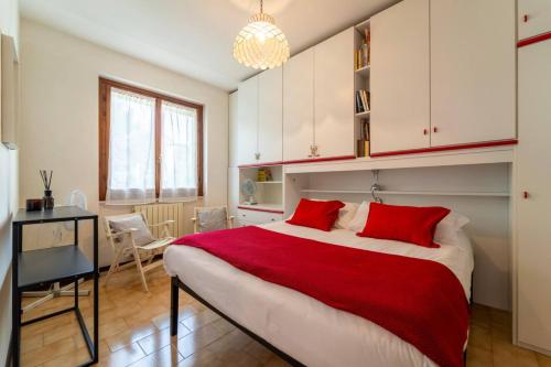 a bedroom with a large bed with red pillows at Primula Comfort Apartment in Bellagio