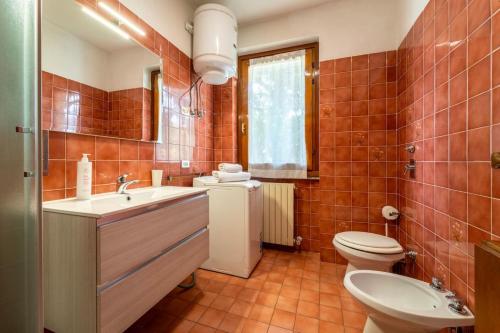 a bathroom with a toilet and a sink and a toilet istg at Primula Comfort Apartment in Bellagio
